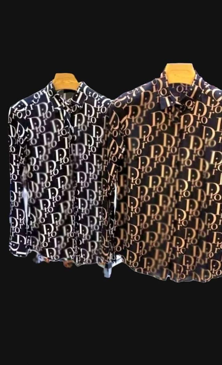 Tip Produs: Cămăși cu mânecă lungă, croială clasică/casual, cu nasturi.
Design/Imprimeu: Ambele cămăși prezintă un imprimeu all-over (pe toată suprafața), format din literele "D I O R" (sau un monogram similar, cum ar fi modelul "Dior Oblique") care se repetă în diagonală.
Cromatica (Culori):
Cămașa din stânga: Imprimeu alb (sau crem deschis) pe un fundal negru sau foarte închis (posibil bleumarin).
Cămașa din dreapta: Imprimeu auriu/bej/maro deschis pe un fundal negru sau foarte închis.